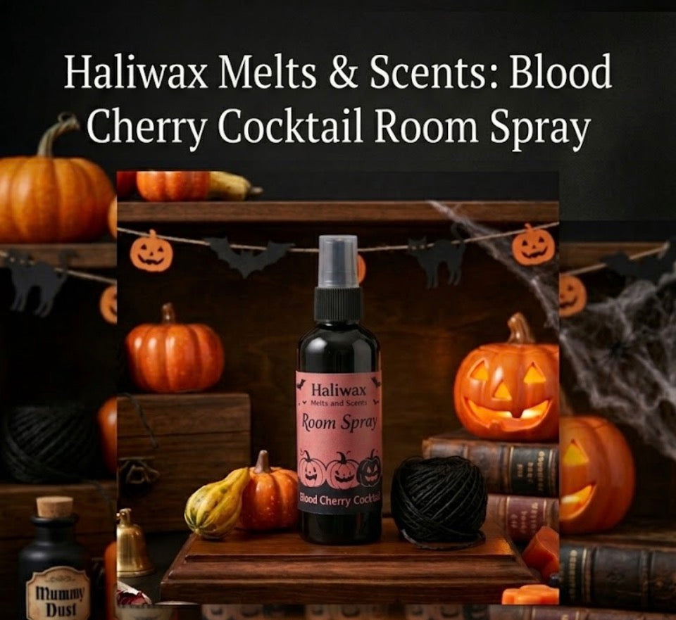 Haliwax Blood Cherry Cocktail Halloween room spray bottle displayed on a dark wooden surface surrounded by pumpkins, jack-o-lanterns, cobwebs and spooky Halloween props.