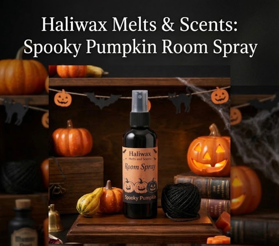 Haliwax Spooky Pumpkin Halloween room spray bottle displayed on a dark wooden surface surrounded by pumpkins, jack-o-lanterns, cobwebs and spooky Halloween props.