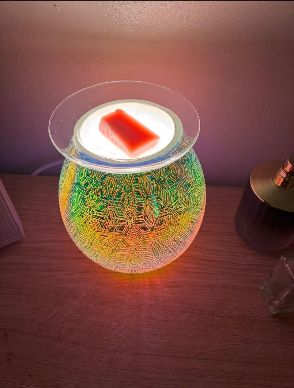 Geometric Flower Electric Oil Burner glowing with rainbow colours and a wax melt on the dish