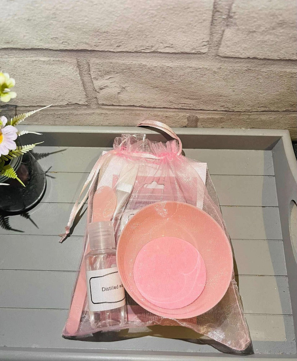 Kaolin clay face mask kit in a pink drawstring gift bag with bowl and accessories